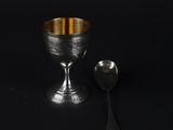 silver goblet and spoon on a black background