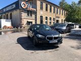 the black bmw car is parked in front of the building