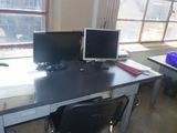 deux écrans d'ordinateur posés sur un bureau devant une fenêtre