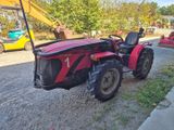 a red tractor that is parked on the side of the road