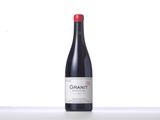 a bottle of red wine sitting on top of a counter
