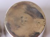 a close up of a silver container with a face on it