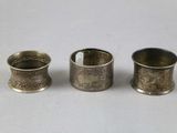 three antique silver napkin holders sitting next to each other on a table