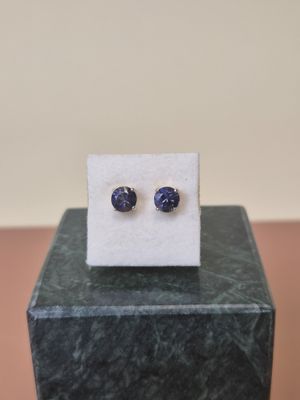 a pair of blue sapphire earrings sitting on top of a marble block