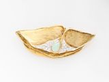 a gold plate with a green stone in it