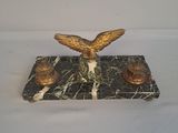 une statue d'aigle posée sur un socle en marbre