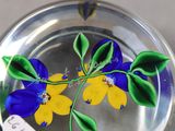 a glass plate with a blue and yellow flower on it