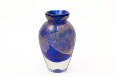 un vase en verre bleu orné d'un motif à la feuille d'or