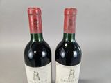 two bottles of red wine sitting next to each other on a table