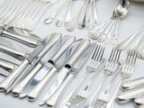 a lot of silver spoons and forks on a table