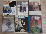 several comic books sitting on top of a wooden floor next to each other