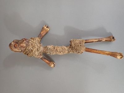 une sculpture en bois représentant une personne allongée par terre