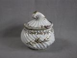 a white vase with a bird on it sitting on a table