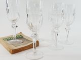 four wine glasses sitting next to a book on a table
