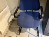 une chaise de bureau bleue posée dans un coin de la pièce
