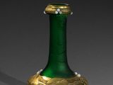 un vase vert et doré orné de perles
