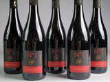 six bouteilles de vin sont alignées sur une table
