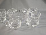several clear glass bowls and cups on a white cloth