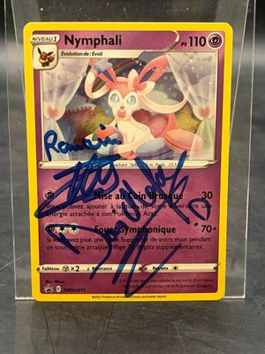 un gros plan sur une carte Pokémon, avec une carte dédicacée