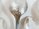 several spoons are lined up in a row on a white surface