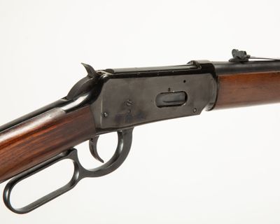 un gros plan d'un fusil sur un fond blanc avec un fond blanc