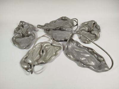 five pieces of silver colored metal on a white surface