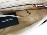 a white purse with a red, white, and blue handle