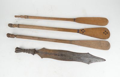 trois vieilles cuillères en bois et un couteau posés sur une surface blanche