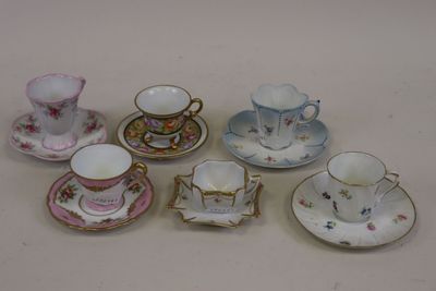cinq tasses et soucoupes posées sur une table