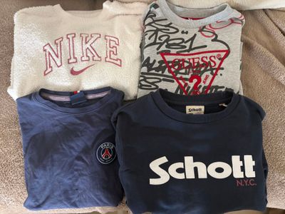 trois t-shirts posés sur un canapé, ornés de graffitis