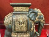 une statue d'éléphant assise sur une table rouge