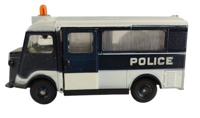un camion de police miniature posé sur une surface blanche