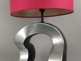 une lampe surmontée d'un abat-jour rose