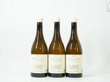 trois bouteilles de vin posées les unes à côté des autres sur une surface blanche
