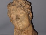 statue of a woman ' s head on a table with a gray background