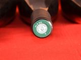 several bottles of wine are lined up on a red surface