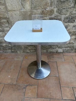a white table with a card on it on a brick floor