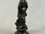 bronze figurine of a boy with a dog on a pedestal