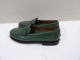 a close up of a pair of green shoes on a white surface