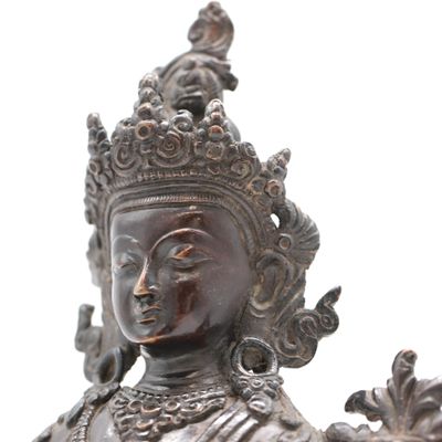 une statue de femme tenant un oiseau dans sa main