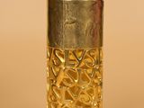 a close up of a bottle of perfume on a beige surface