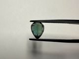 a close up of a pair of pliers holding a green heart shaped diamond
