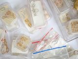 many different types of jewelry in plastic containers on a table