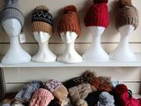many hats and mittens on display on a shelf
