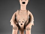 un gros plan sur la statue d'un homme tenant un bébé dans ses bras