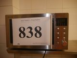 a microwave with a clock on top of it on a shelf