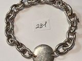 a silver bracelet with a silver button on it