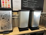 three coffee machines sitting on a table in a coffee shop