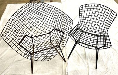 une paire de chaises noires en fil de fer posées sur un drap blanc