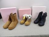 three pairs of women ' s boots are lined up on a table